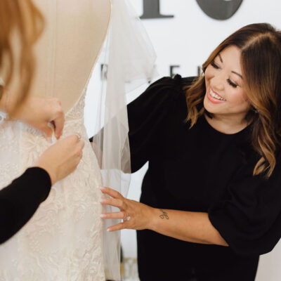 Revelle Bridal Boutique Ottawa - Boutique Owner Earleen fixing pins on boho wedding dress on mannequin - BANNER