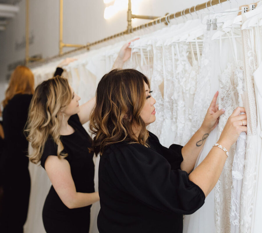Revelle Bridal Boutique Ottawa - Revelle Bridal Stylist Team Looking through rack of dresses Earleen Claire