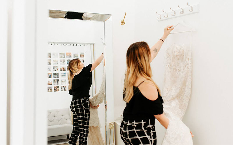 Revelle Ottawa Bridal Boutique Westboro - Wellington Location Claire placing wedding dress in fitting room