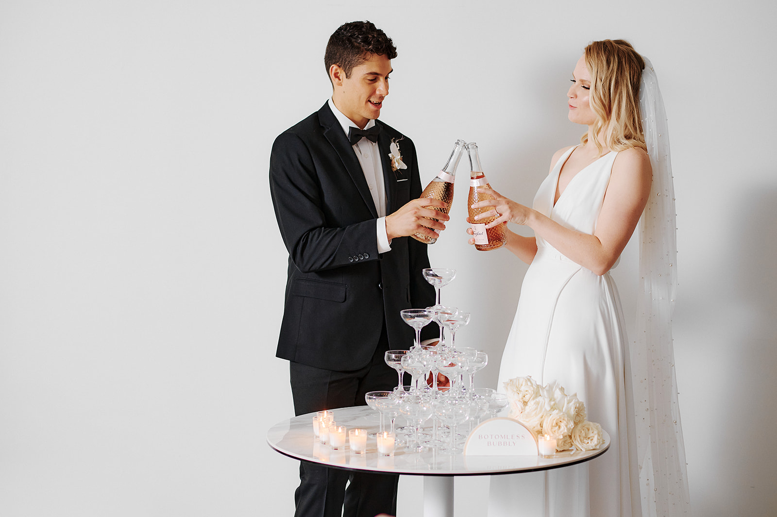 Bash by BLVD Revelle x Maide Arlo Wedding Gown Couple Cheers Champagne Tower Affordable Luxury