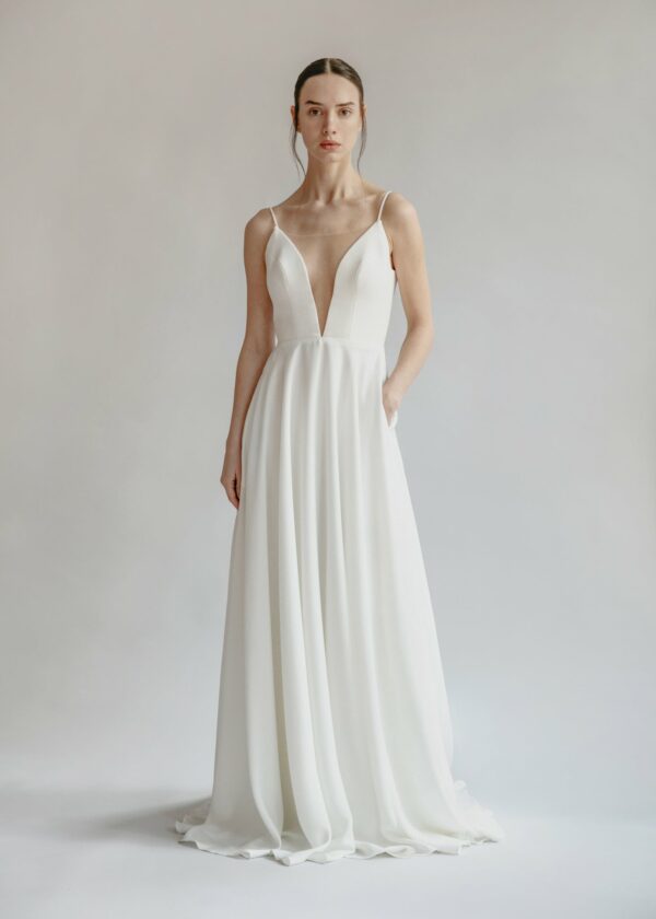 Orenda by Aesling flowy a-line skirt with plunging neckline and train available for purchase at Revelle Bridal