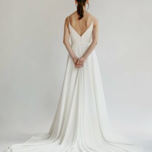 Orenda by Aesling flowy a-line skirt with plunging neckline and train available for purchase at Revelle Bridal back