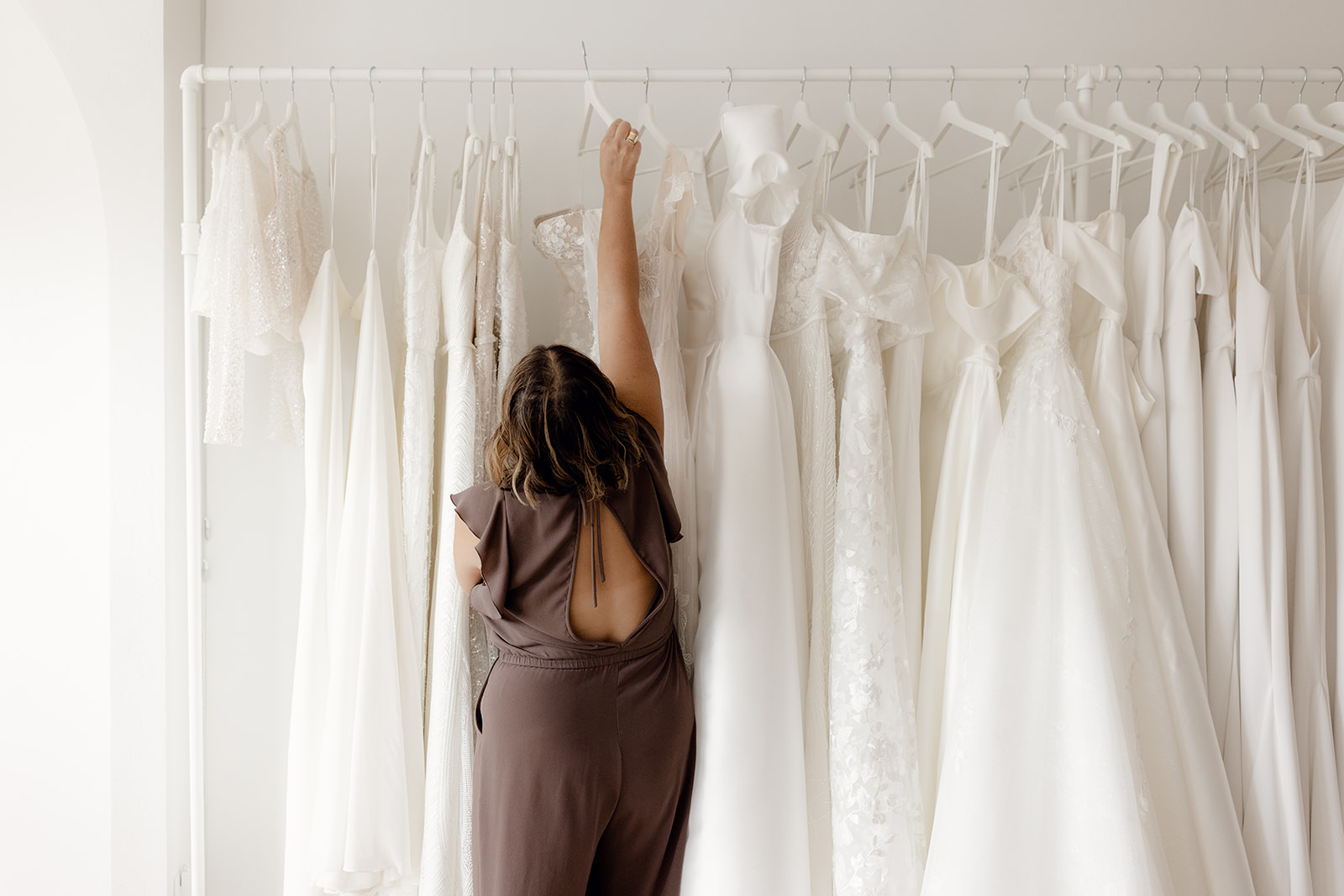 REVELLE Bridal Boutique Ottawa Wedding Dress Rack Pulling Gowns for Clients