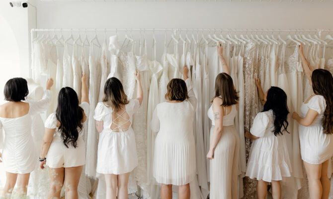 Revelle Bridal Boutique Ottawa - Bridal Team Adjusting Dresses on the rack- pulling wedding gowns from the rack Earleen Marisa Micha Paula Elizabeth