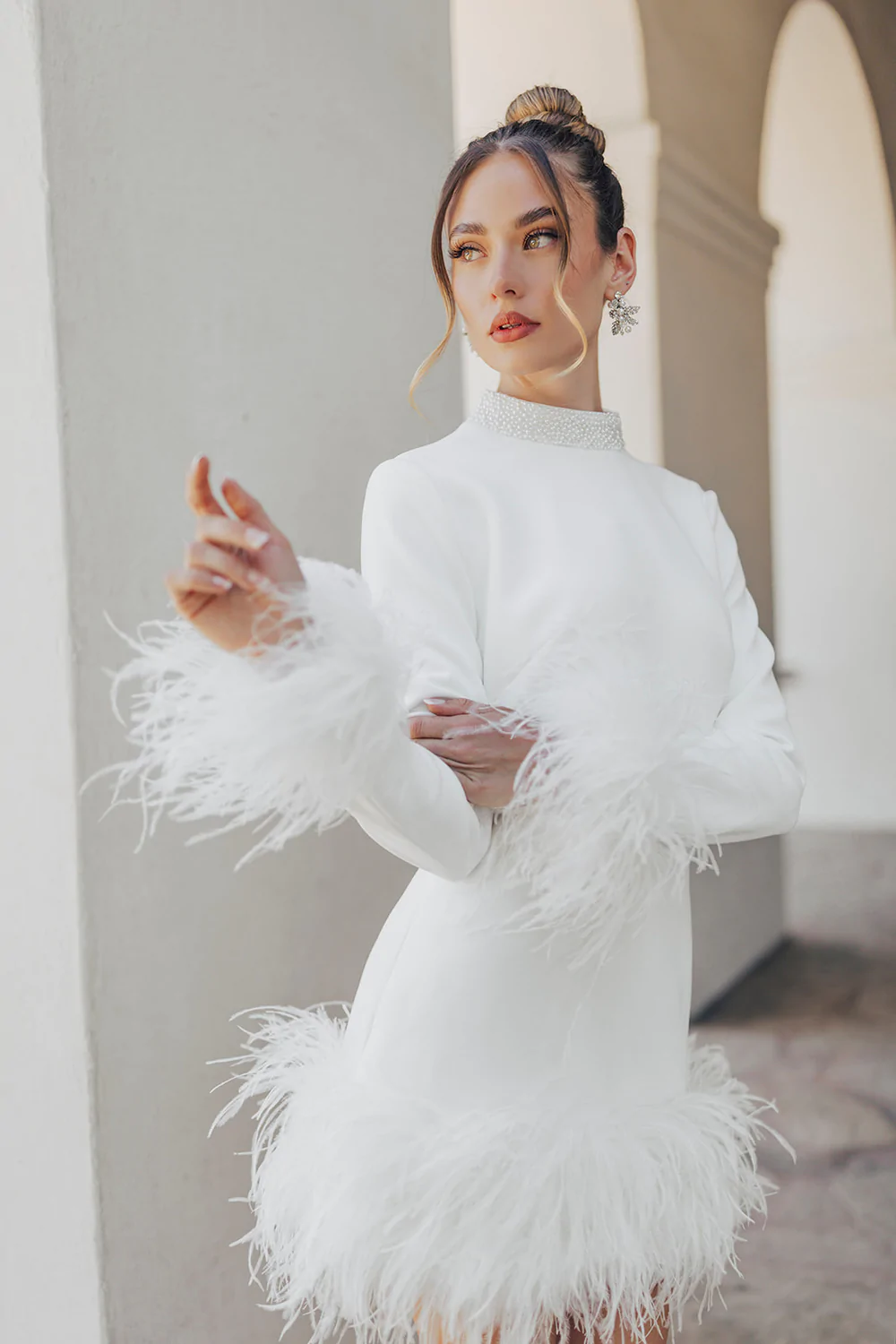 https://revellebridal.com/wp-content/uploads/2023/04/Clara-Untamed-Petals-Mini-Bridal-Dress-Crepe-Long-Sleeve-Dress-Feather-Trims-Cuffs-Hem-Made-To-Order-Second-Look.webp